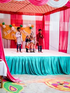 Students performing in a cultural program on stage